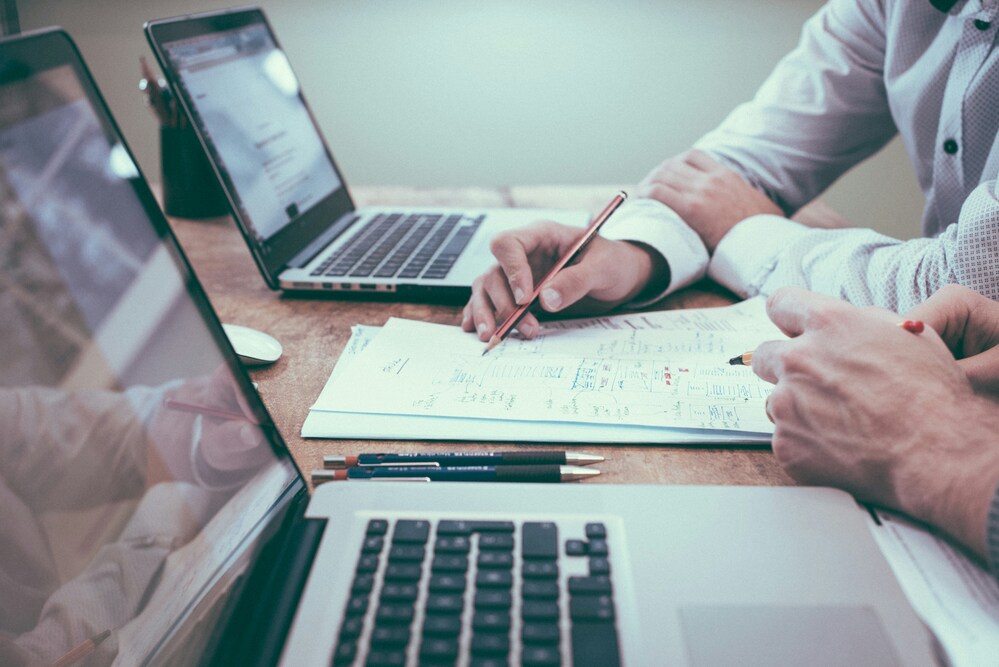Two people reviewing financial documents during the due diligence stage of an acquisition.